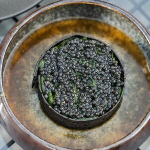 Close-up of gourmet black caviar in a rustic bowl, showcasing rich textures and luxury.