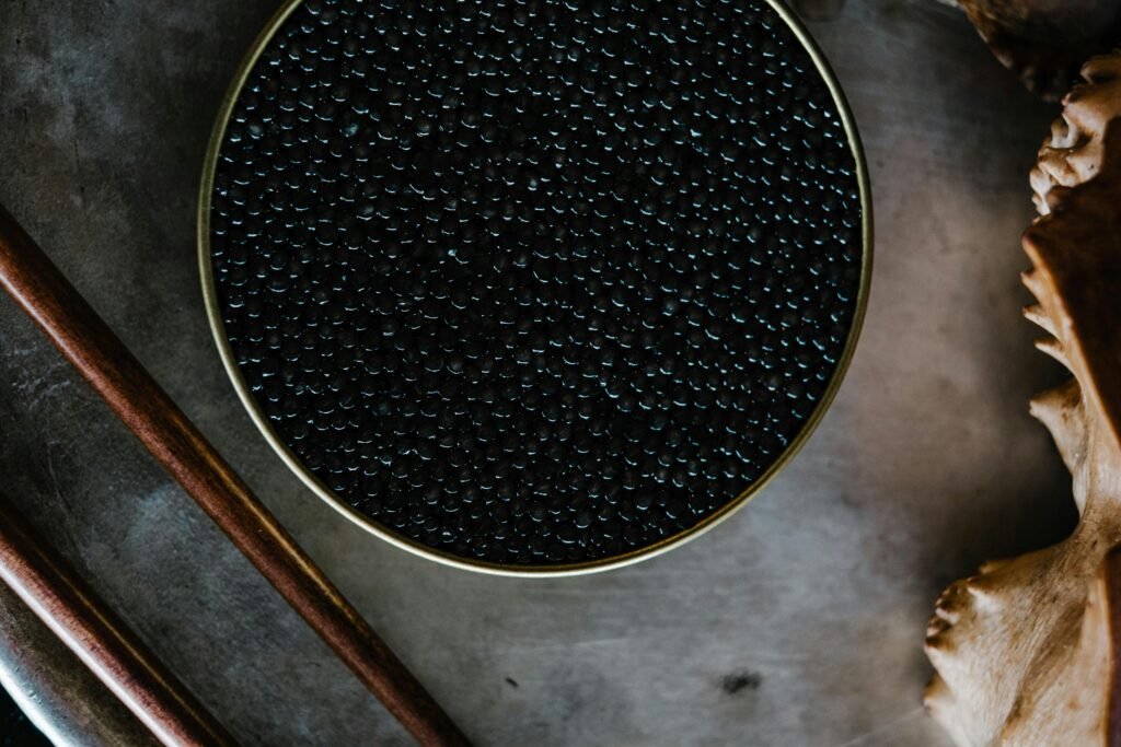 Close-up of black caviar in a tin, showcased with a rustic culinary aesthetic.