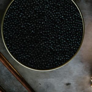 Close-up of black caviar in a tin, showcased with a rustic culinary aesthetic.